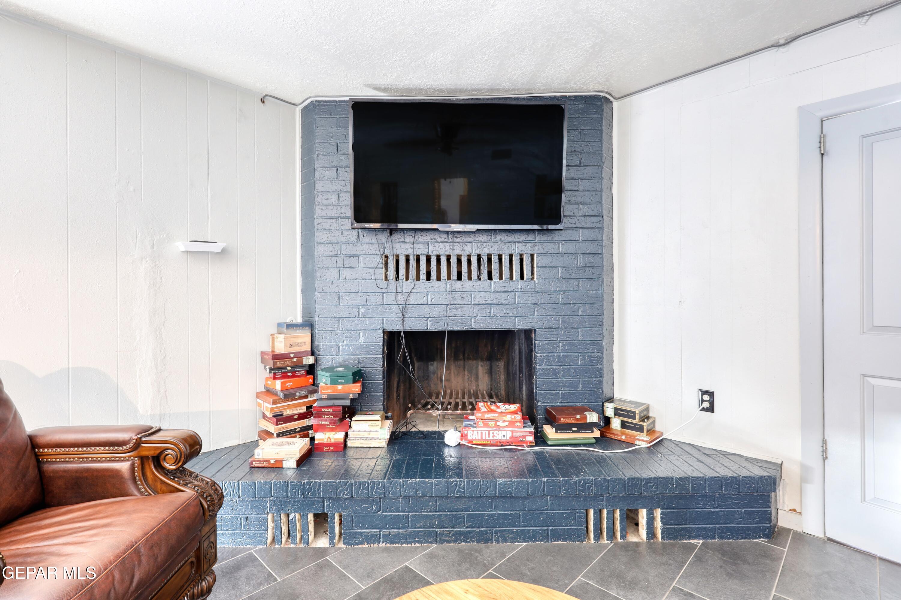 5912 Delta Drive El Paso, TX 79905 - Photo 15 of 37 a living room with furniture a fireplace and a flat screen tv
