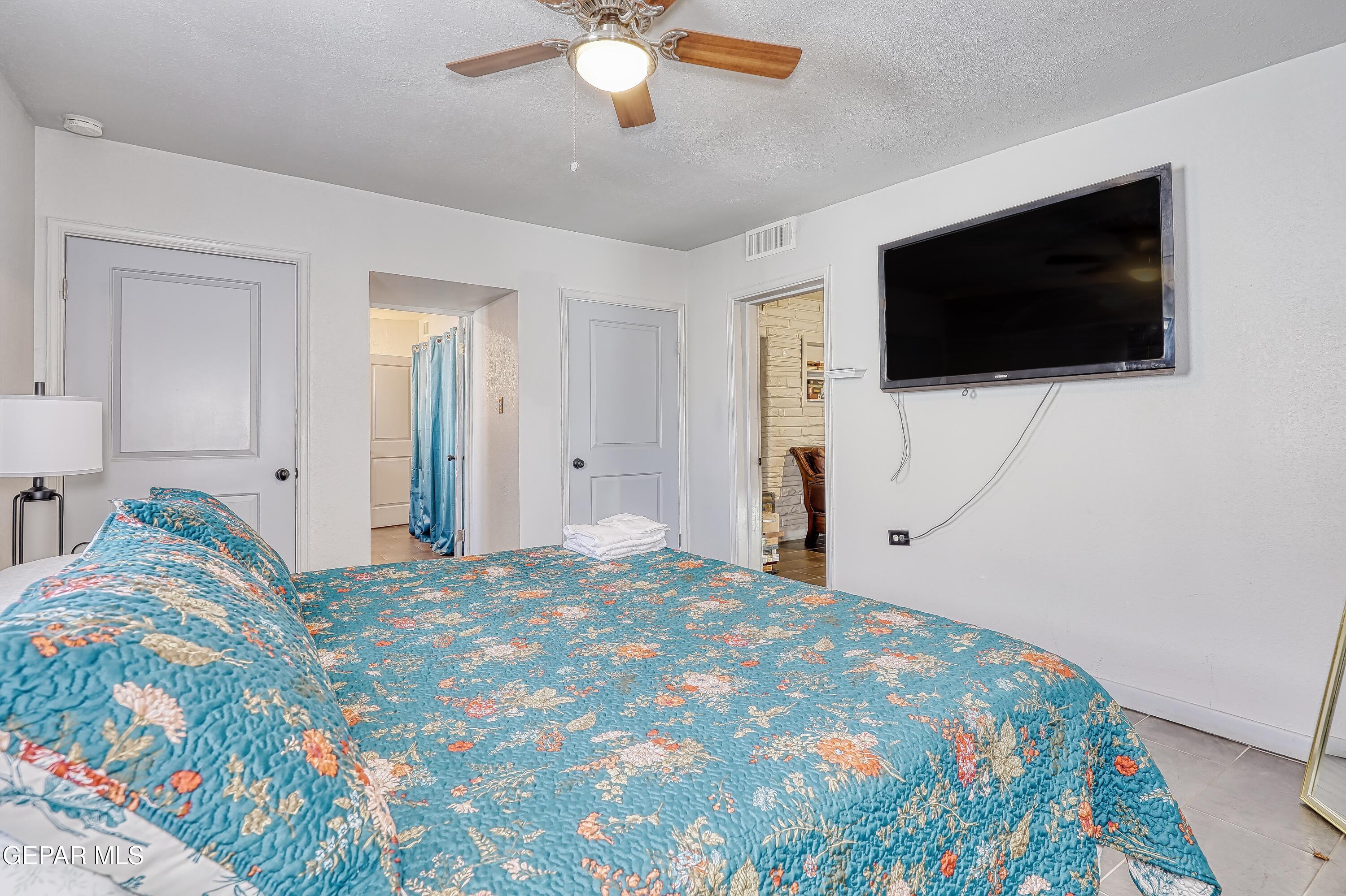 5912 Delta Drive El Paso, TX 79905 - Photo 20 of 37 a spacious bedroom with a bed and a flat screen tv