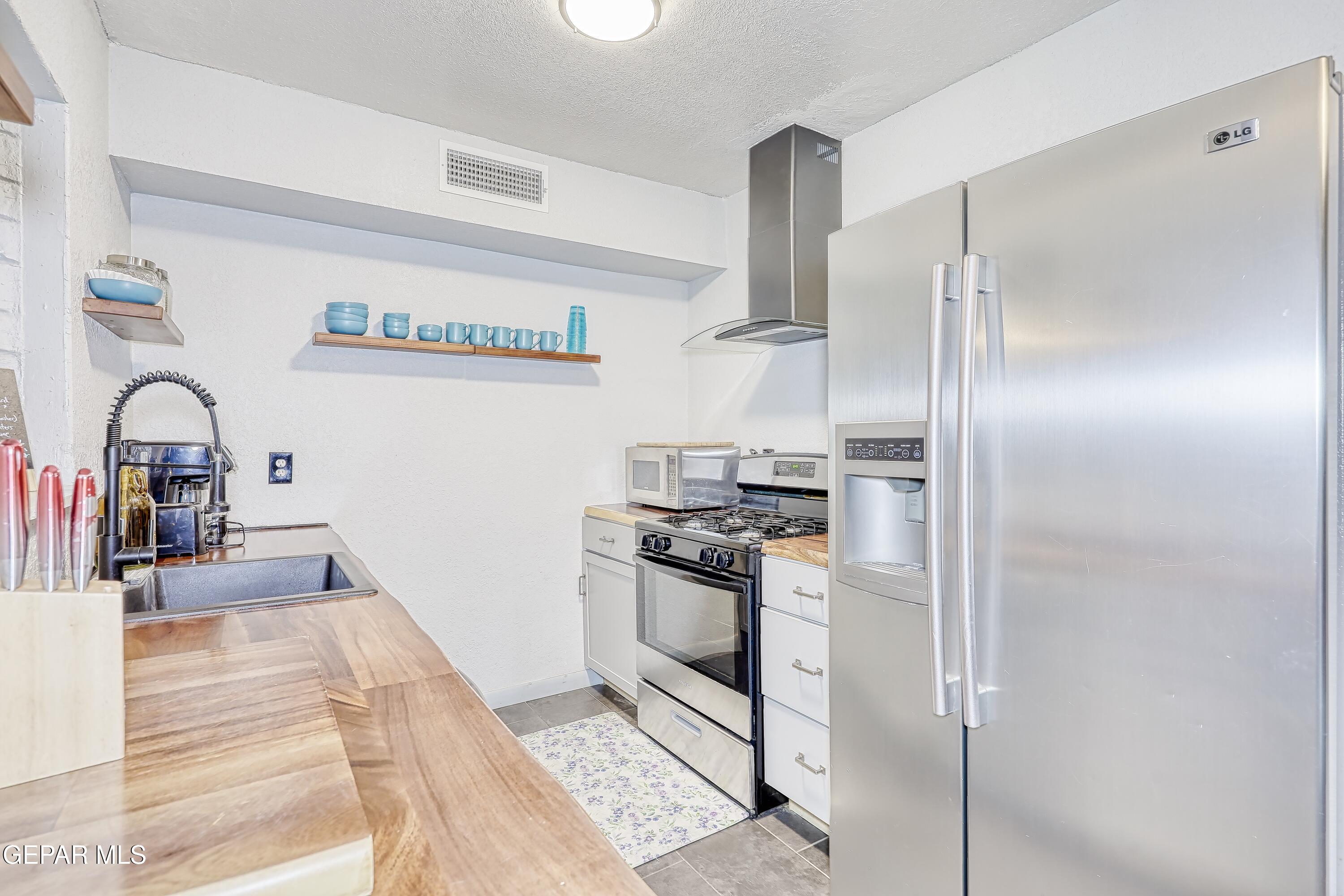 5912 Delta Drive El Paso, TX 79905 - Photo 8 of 37 a kitchen with stainless steel appliances granite countertop a refrigerator and a sink