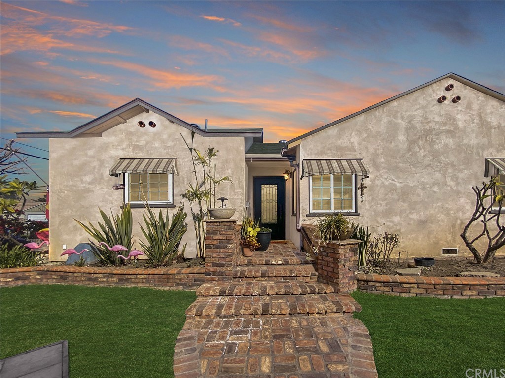 9503 Epsom Place Pico Rivera, CA 90660 - Photo 1 of 1 a view of a brick house with many windows next to a yard
