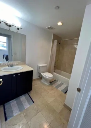 a spacious bathroom with a sink a toilet and a mirror