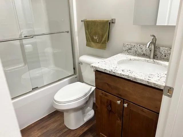 a bathroom with a granite countertop sink toilet and shower