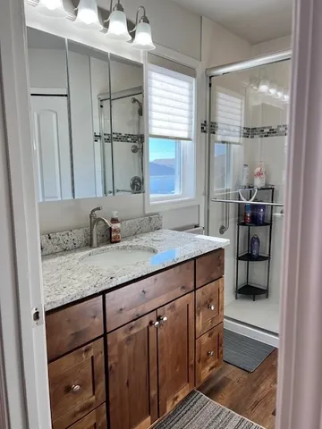 a bathroom with a granite countertop sink a toilet and a shower