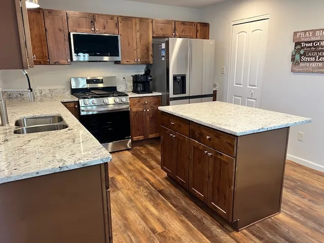 a kitchen with stainless steel appliances granite countertop a sink stove and refrigerator
