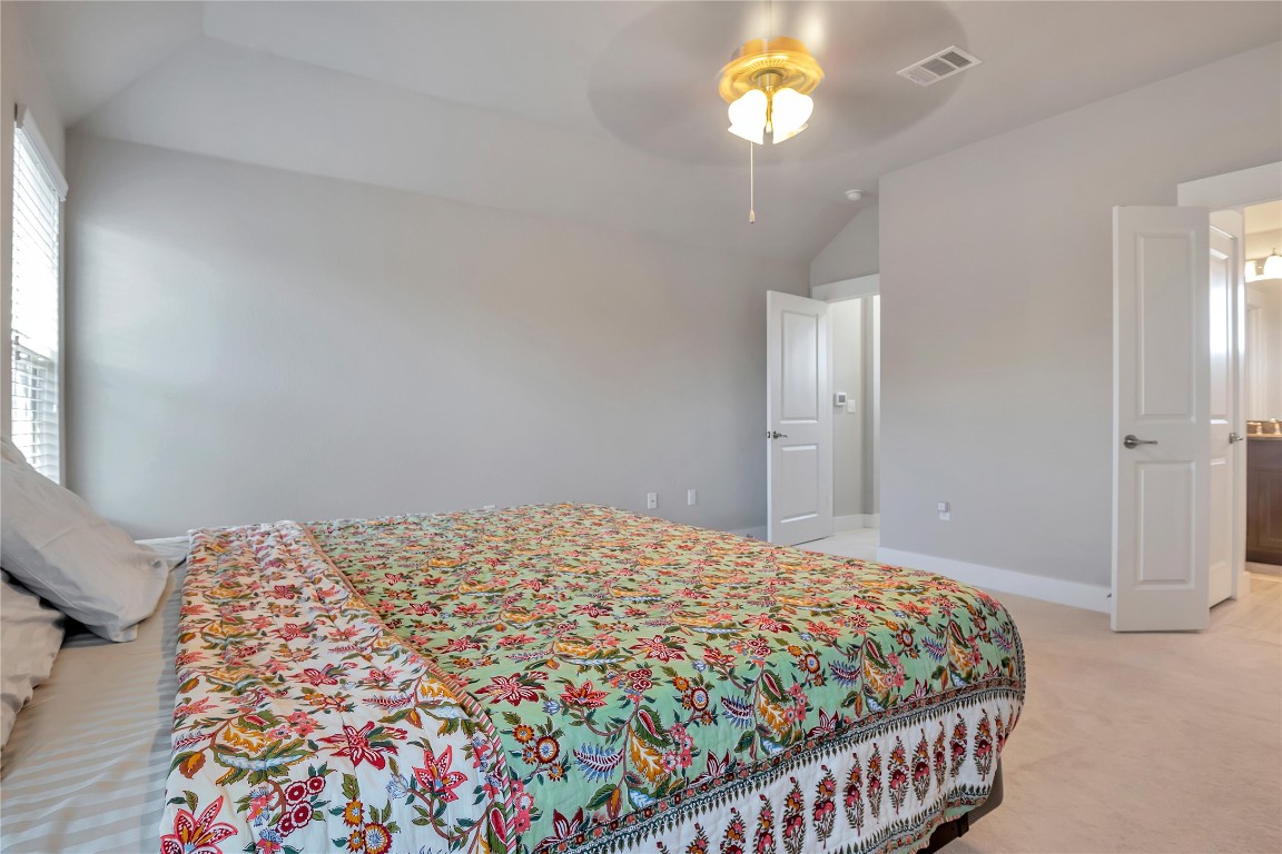 9302 McKnight Loop, Unit 43 Austin, TX 78717 - Photo 17 of 24 a bedroom with a bed and a chandelier
