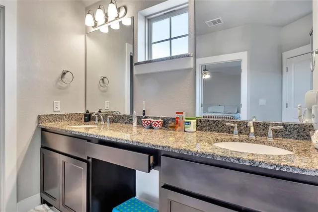 a bathroom with double sink and a mirror