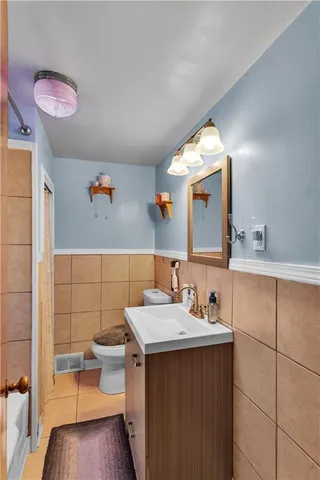 a bathroom with a sink mirror and toilet