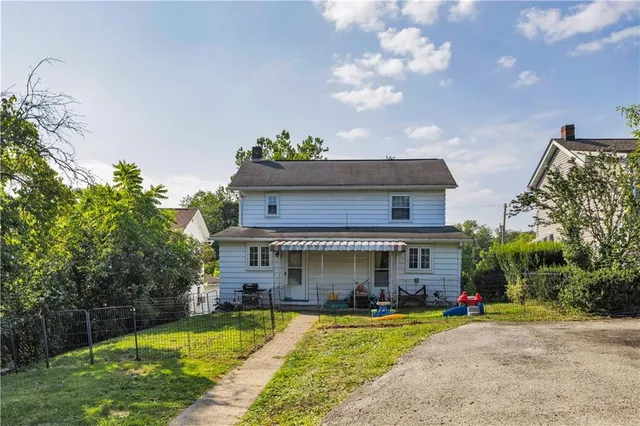 a front view of a house with swimming pool and a yard
