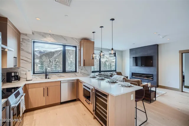 a kitchen that has a sink a stove and chairs