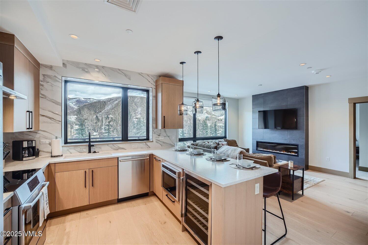 42 Riverfront Lane, Unit 205 Avon, CO 81620 - Photo 3 of 20 a kitchen that has a sink a stove and chairs
