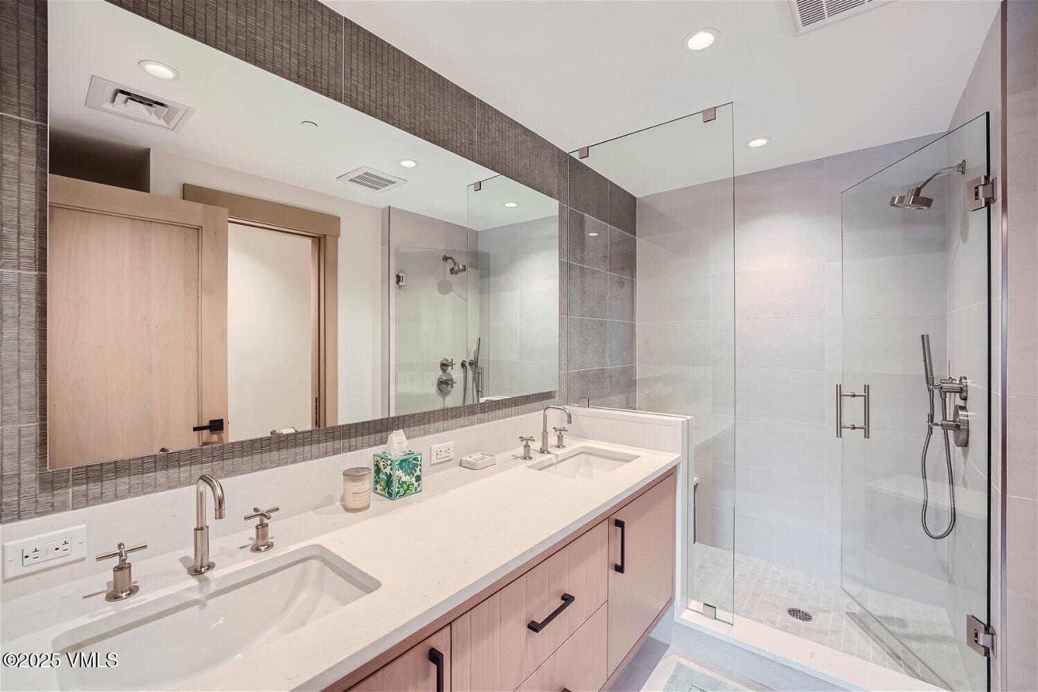 42 Riverfront Lane, Unit 205 Avon, CO 81620 - Photo 5 of 20 a bathroom with a shower sink double vanity and mirror