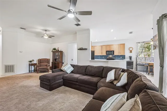 a kitchen with stainless steel appliances granite countertop a refrigerator a sink dishwasher a stove and white cabinets with wooden floor