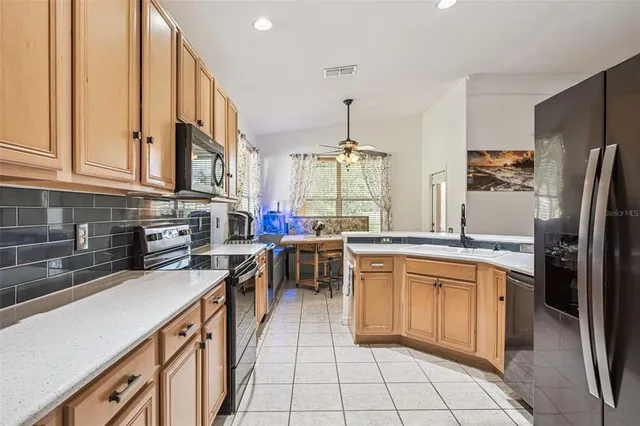 a kitchen with stainless steel appliances granite countertop a refrigerator and a sink