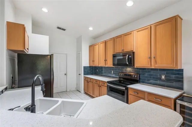 a kitchen with stainless steel appliances a sink a stove and a refrigerator