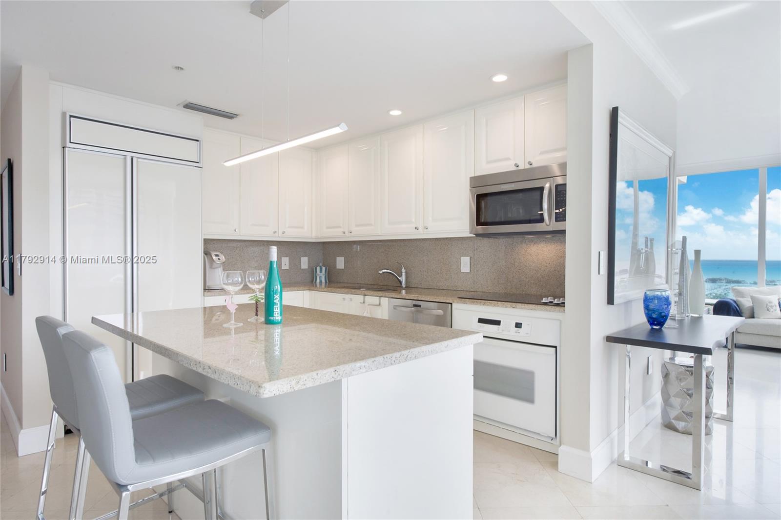 3400 Southwest 27th Avenue, Unit 1003 Coconut Grove, FL 33133 - Photo 4 of 18 a kitchen with stainless steel appliances granite countertop a stove a sink and a refrigerator