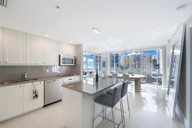 a kitchen with a dining table chairs and white cabinets