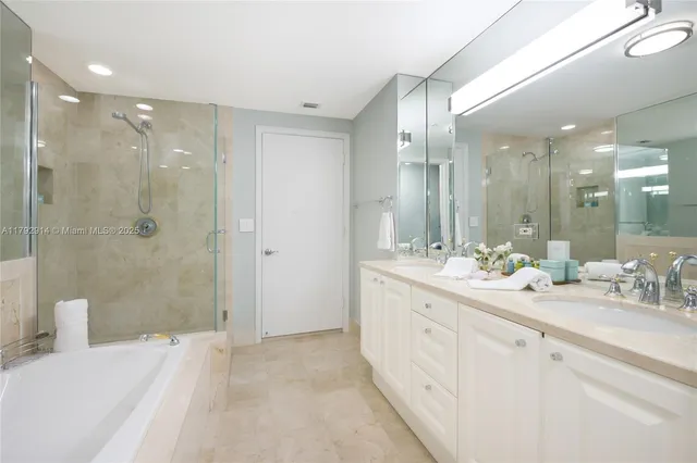 a bathroom with a double vanity sink mirror and shower