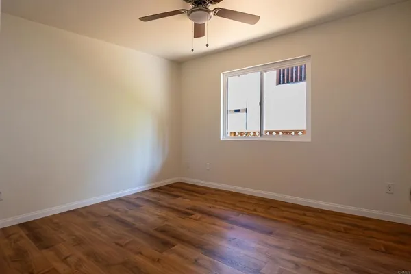 a view of an empty room with wooden floor