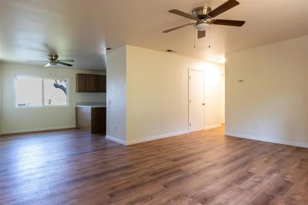 a view of a kitchen with a wooden floor and a ceiling fan