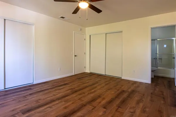a view of an empty room with wooden floor