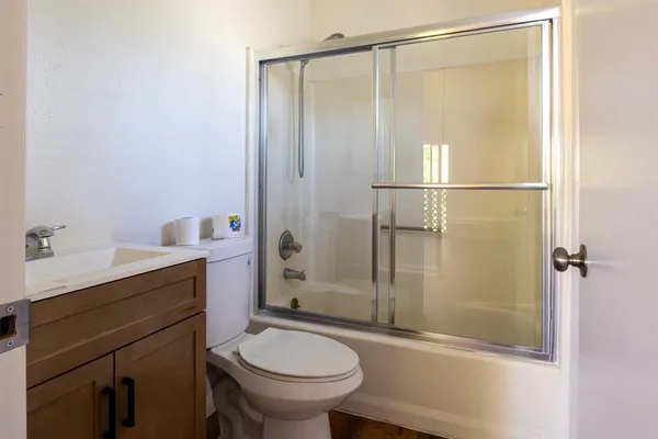 a bathroom with a granite countertop sink toilet and shower
