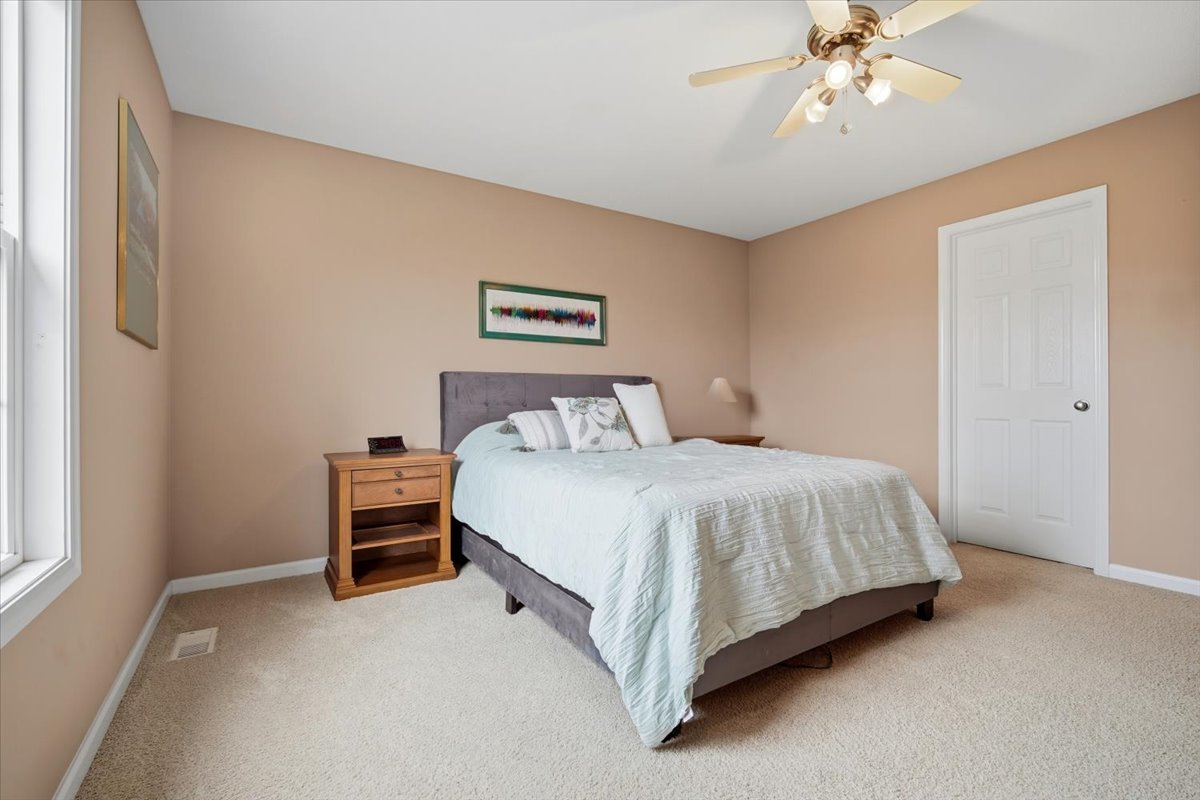 2429 Grey Fox Trail Bloomington, IL 61705 - Photo 18 of 43 a bedroom with a bed and a chandelier