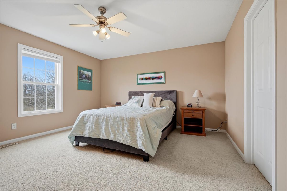 2429 Grey Fox Trail Bloomington, IL 61705 - Photo 19 of 43 a spacious bedroom with a bed and a chandelier