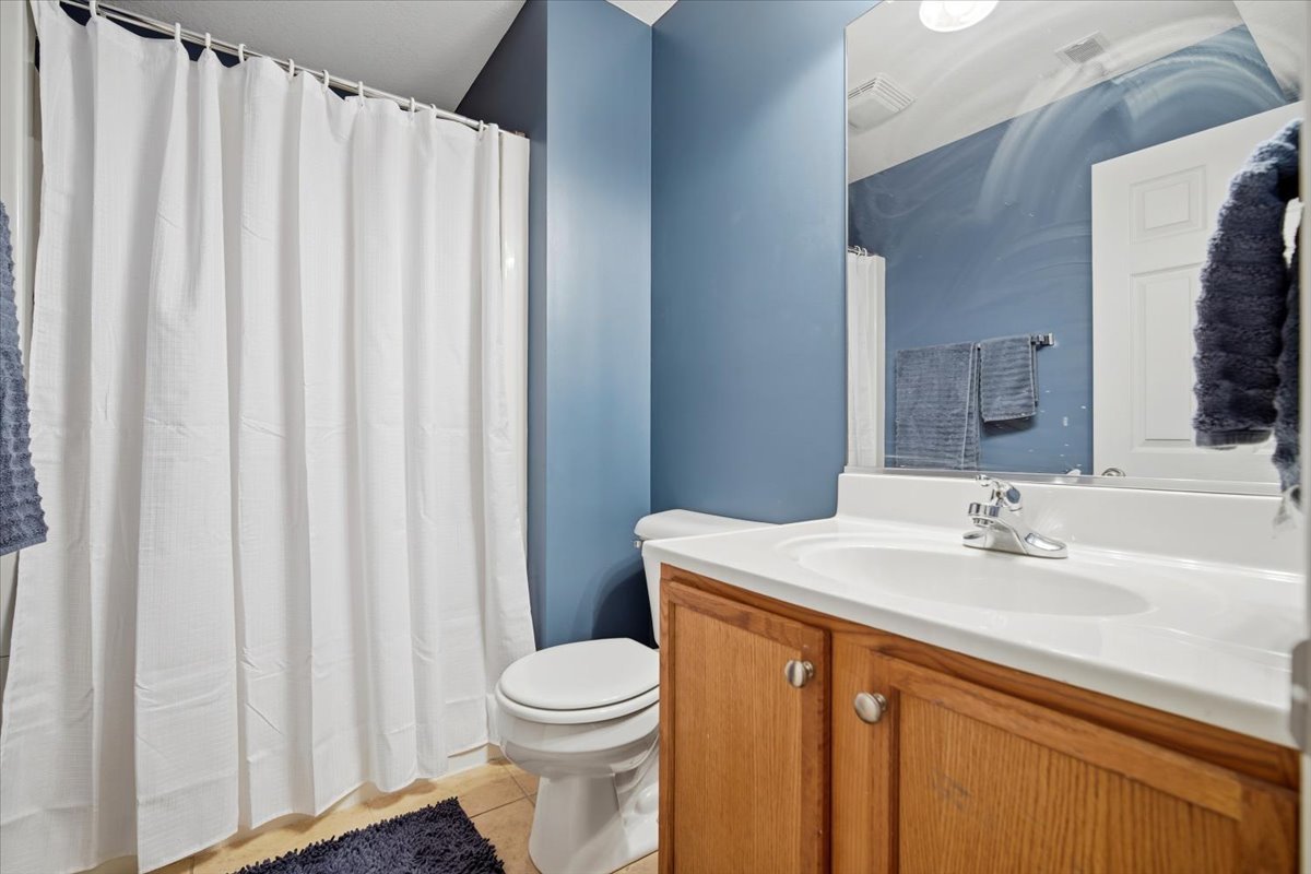 2429 Grey Fox Trail Bloomington, IL 61705 - Photo 30 of 43 a bathroom with a sink a toilet and shower curtain