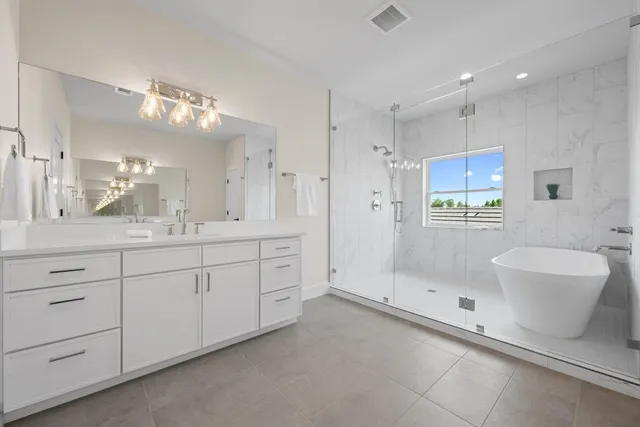 a spacious bathroom with a double vanity sink a mirror and a bathtub
