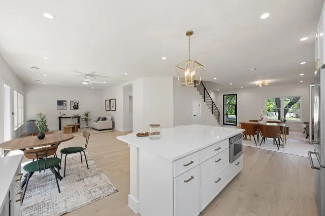 a large white kitchen with a table and chairs