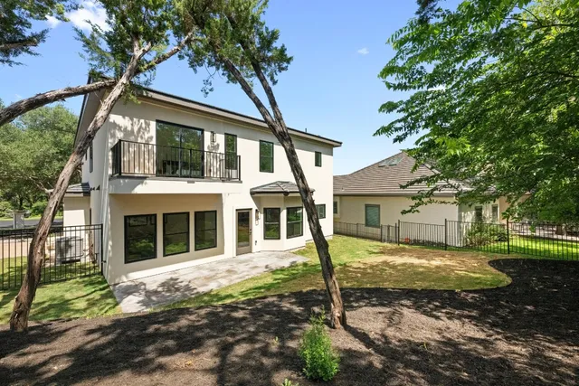 an aerial view of a house with a yard and trees all around