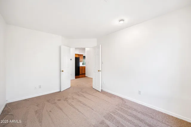 a view of an empty room with a fireplace and a window