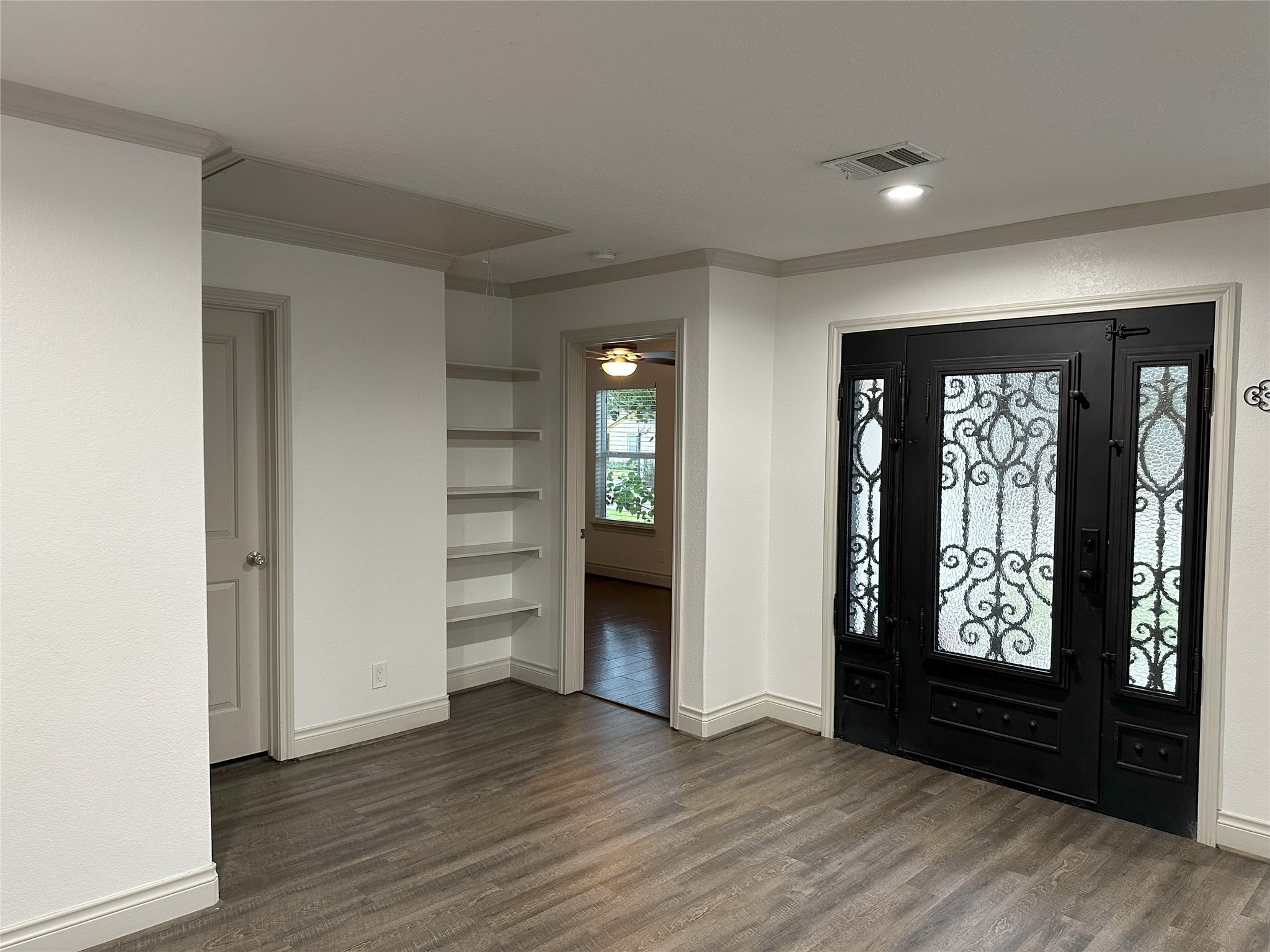 6646 Limestone Street Houston, TX 77092 - Photo 3 of 23 an empty room with wooden floor cabinet and windows