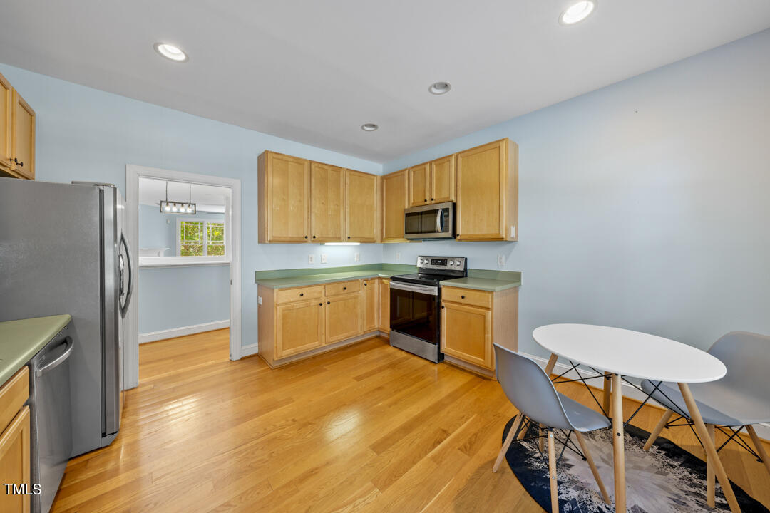 203 Bluefield Road Chapel Hill, NC 27517 - Photo 11 of 34 a kitchen with stainless steel appliances a stove a sink a refrigerator white cabinets and wooden floor