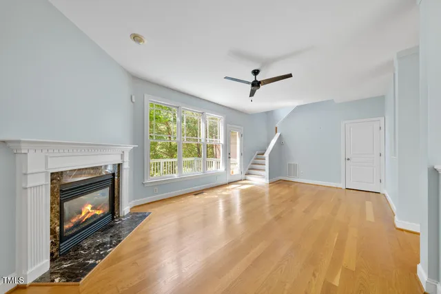 a view of empty room with wooden floor and fireplace