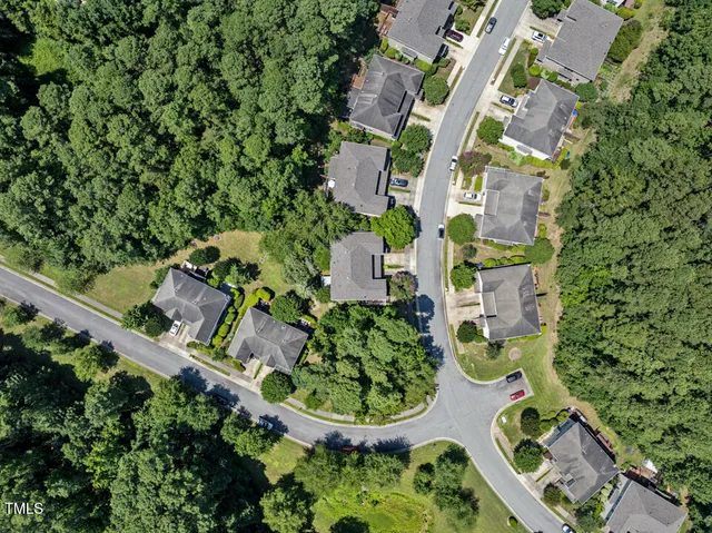 an aerial view of residential house with outdoor space and trees all around
