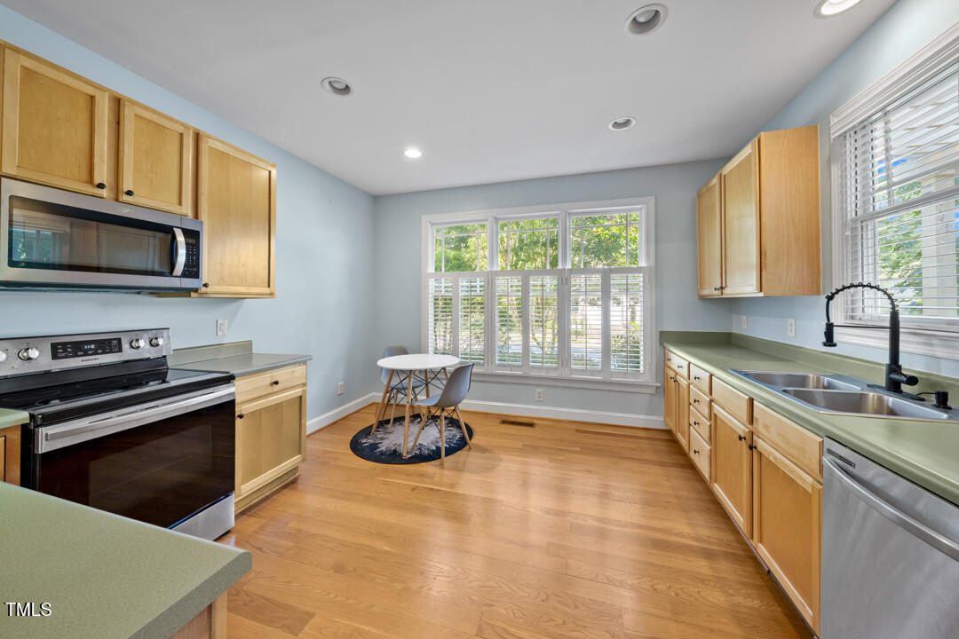 203 Bluefield Road Chapel Hill, NC 27517 - Photo 6 of 34 a large kitchen with stainless steel appliances granite countertop a stove a sink and a microwave