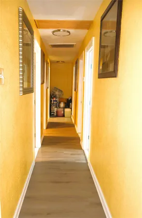 a view of a hallway with wooden floor and a living room