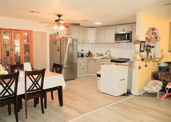 a kitchen with a table chairs refrigerator and cabinets