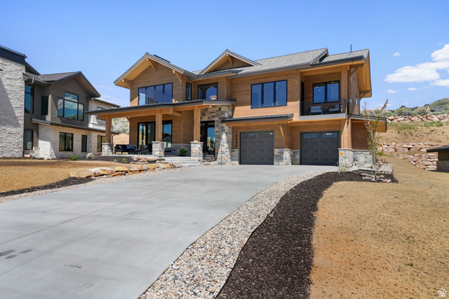 10646 North Reflection Ridge Hideout, UT 84036 - Photo 4 of 43 Contemporary architecture featuring wood paneling, stone accents, and a multi-car garage