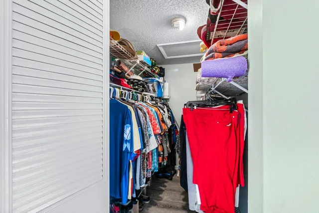 a view of walk in closet with clothes and shoes
