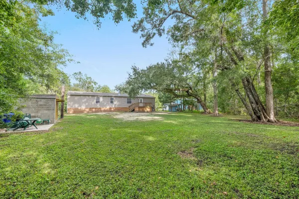 a view of a house with backyard and sitting area