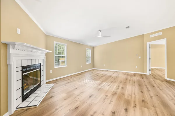 a view of empty room with wooden floor and fireplace