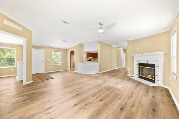 an empty room with wooden floor and window