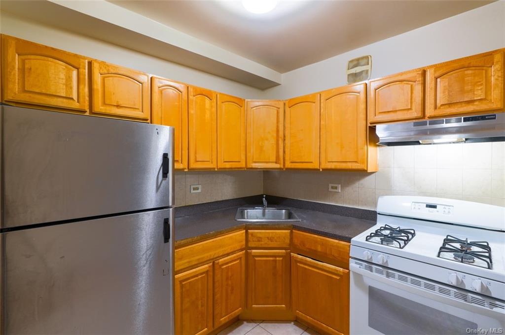a kitchen with stainless steel appliances granite countertop a refrigerator a stove and a sink with cabinets
