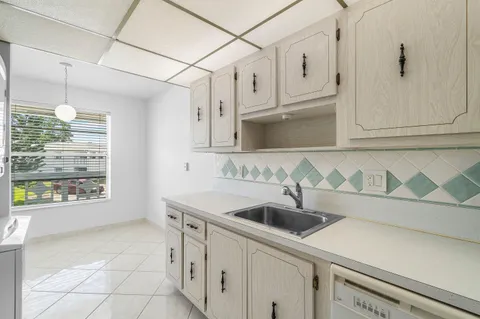 a kitchen with stainless steel appliances granite countertop a sink and a white cabinets
