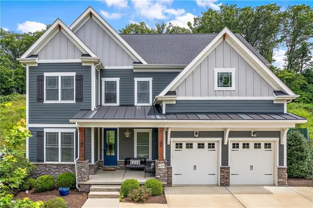 a view of a big house with a yard and plants
