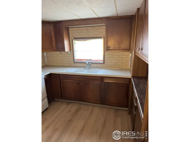 a utility room with wooden floor and a refrigerator