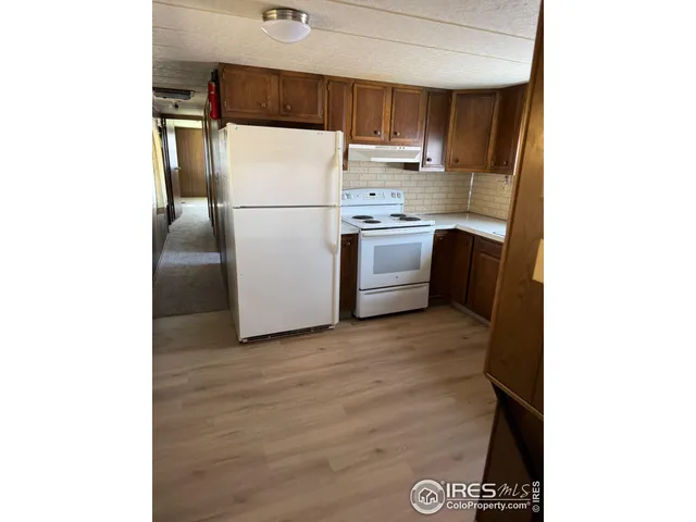 a view of a hallway with kitchen and furniture