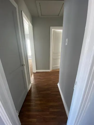 a view of a hallway with wooden floor and staircase